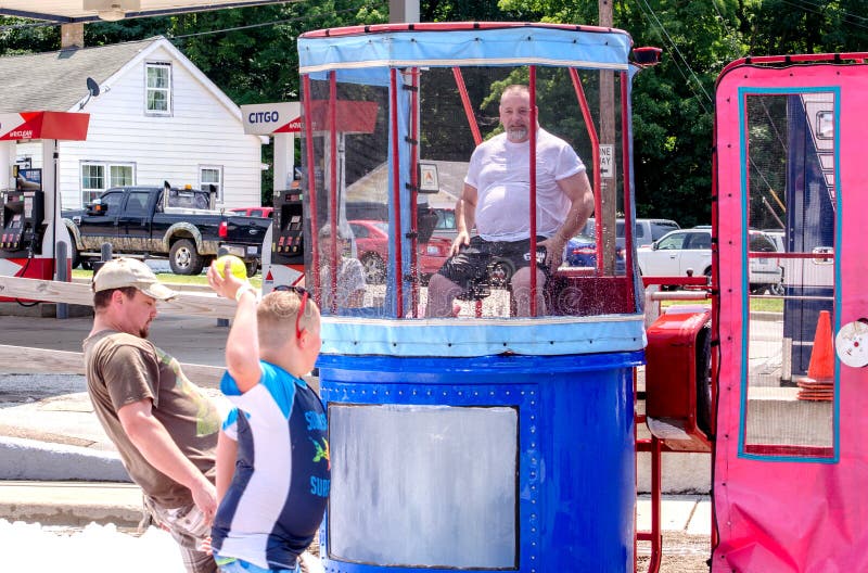 Active boy throws a ball at a dunk tank target