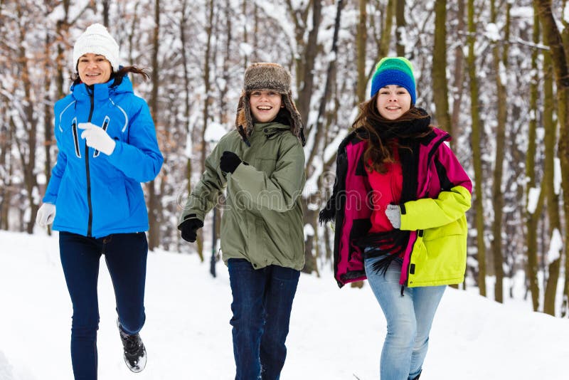 Active family - mother and kids running outdoor in winter park