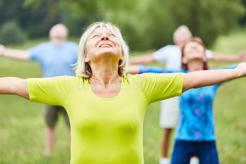 Group of seniors is doing gymnastics in the park