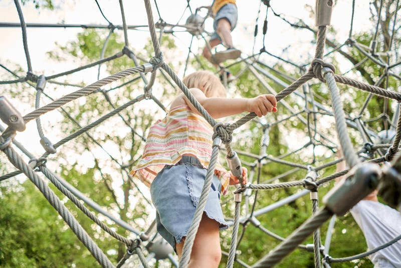 Active Little Child Playing on Climbing Net and Jumping on Trampoline ...