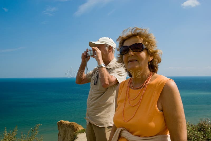 Active traveling older couple outdoor by a lake. Active traveling older couple outdoor by a lake