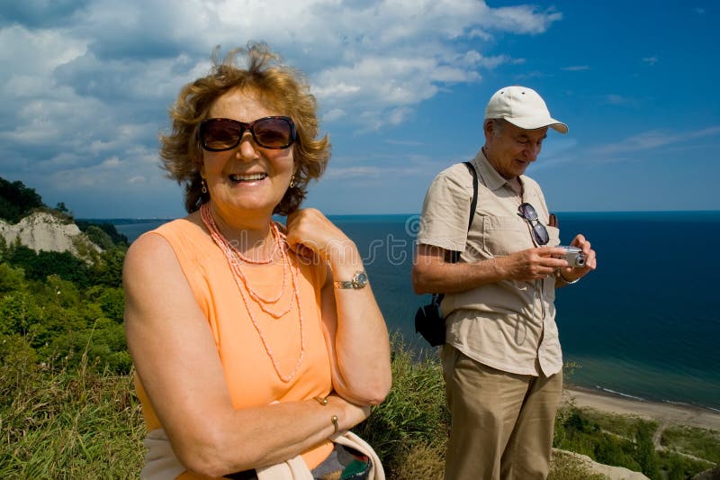 Active traveling older couple outdoor by a lake. Active traveling older couple outdoor by a lake