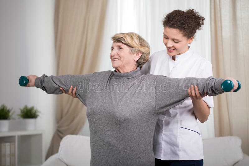 Active older lady exercising arms with dumbbells