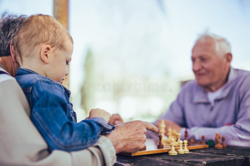Senior men having fun and playing chess at park stock image Senior men having fun and playing chess at park stock image