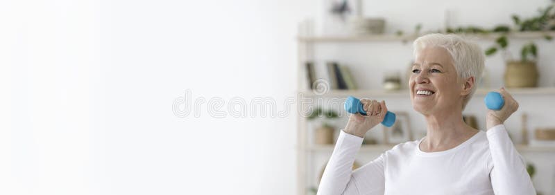 Active Retirement. Sporty senior woman exercising with dumbbells at home royalty free stock images Active Retirement. Sporty senior woman exercising with dumbbells at home royalty free stock images