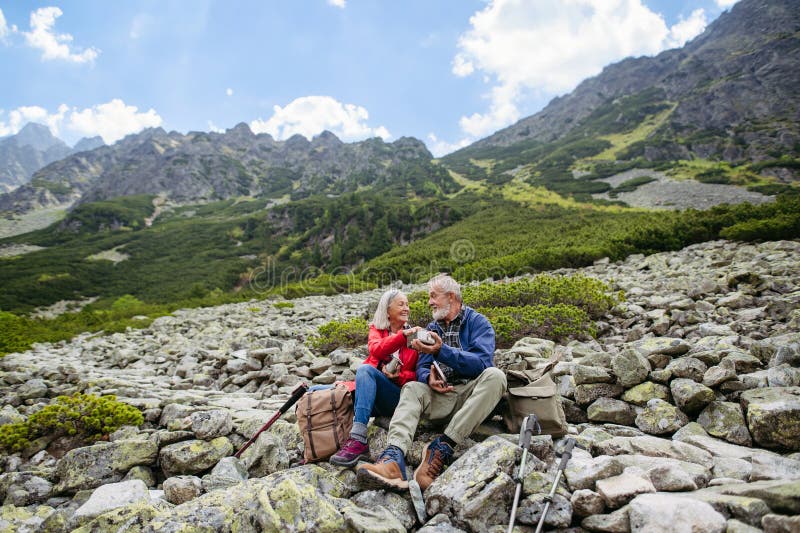 Active senior couple hiking together in autumn mountains.