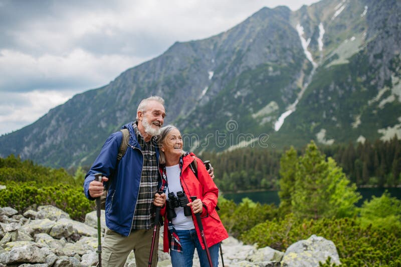 Aktívny starší pár spolu na turistike v jesenných horách.