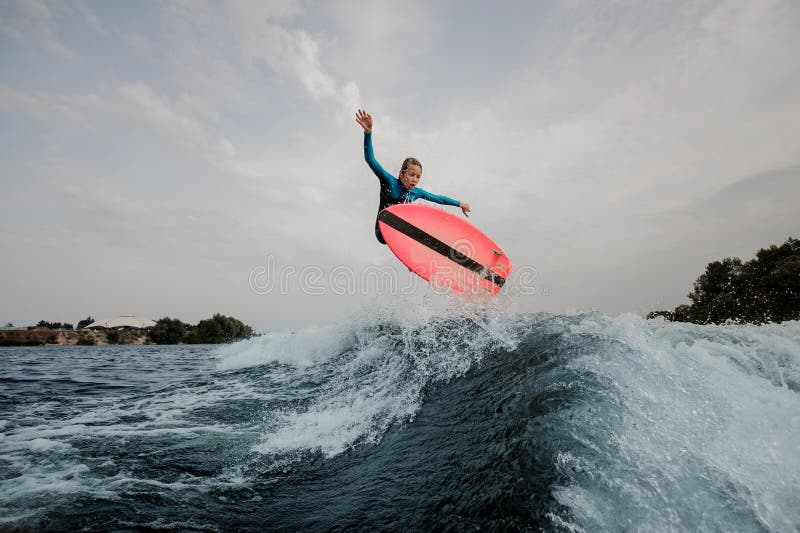 Active teenager boy jumping on the orange wakeboard stock photography Active teenager boy jumping on the orange wakeboard stock photography