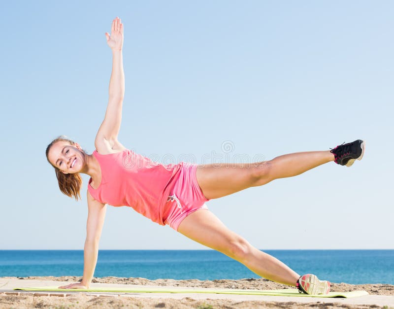 Active young woman exercising on exercise mat outdoor royalty free stock photo Active young woman exercising on exercise mat outdoor royalty free stock photo