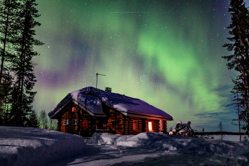 Actividad ártica polar de Aurora Borealis de la aurora boreal sobre la casa de madera en el invierno Finlandia, Laponia fotografía de archivo Actividad ártica polar de Aurora Borealis de la aurora boreal sobre la casa de madera en el invierno Finlandia, Laponia fotografía de archivo