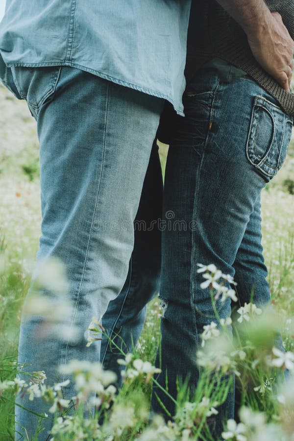 Activités de plein air romantique et couple amoureux embrasser et embrasser au milieu des fleurs de printemps vert prairie. photographie stock libre de droits
