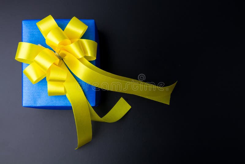 Actual diseño de la caja de regalo envuelto en papel del color con los arcos en un bl foto de archivo libre de regalías Actual diseño de la caja de regalo envuelto en papel del color con los arcos en un bl foto de archivo libre de regalías