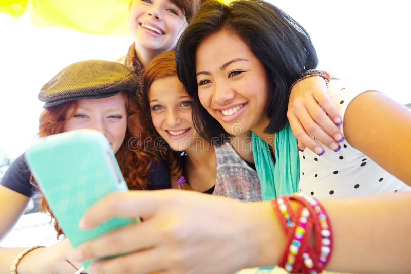 Lets update our profile pictures. A group of adolescent girls laughing as they look at something on a smartphone screen. Lets update our profile pictures. A group of adolescent girls laughing as they look at something on a smartphone screen