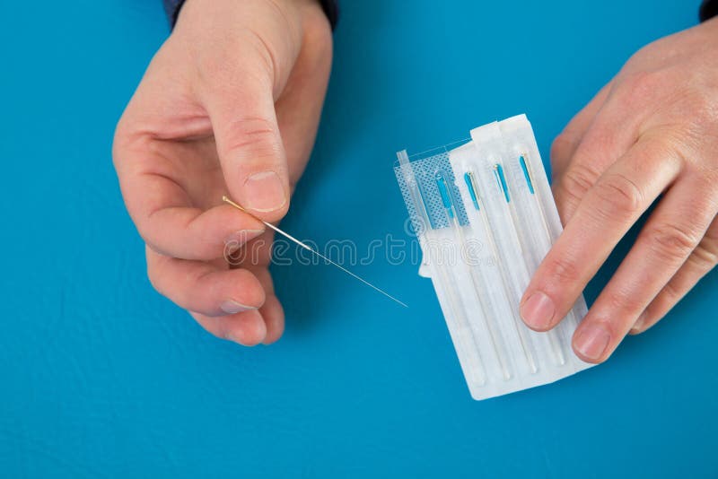 Acupuncture needles in doctor hands holding blister royalty free stock photo