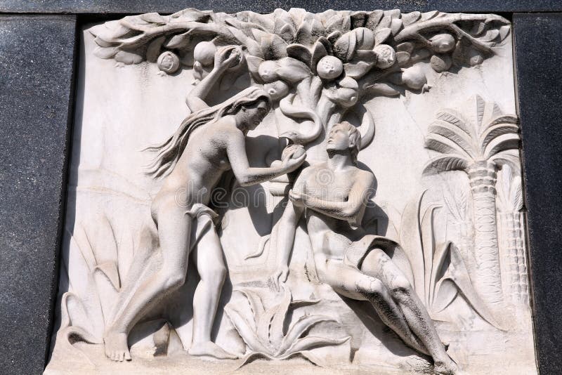 Milan, Italy. Old biblical scene sculpture at the Monumental Cemetery (Cimitero Monumentale). Religious art depicting Adam and Eve picking the fruit in the garden of Eden. Fruit scene stock images, royalty-free photos and pictures