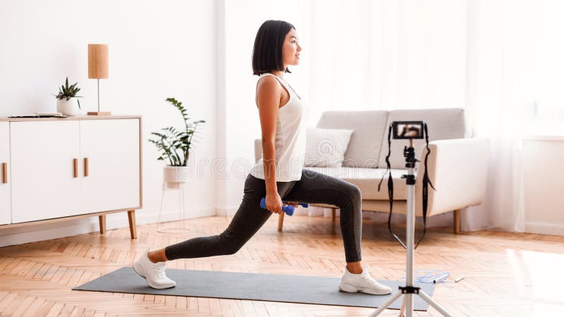 Adaptar ejercicios de filmación de entrenadores asiáticos para entrenamiento en casa imagenes de archivo