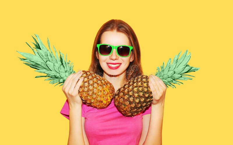 Adatti a ritratto la donna e l'ananas sorridenti graziosi due in occhiali da sole sopra giallo fotografia stock Adatti a ritratto la donna e l'ananas sorridenti graziosi due in occhiali da sole sopra giallo fotografia stock