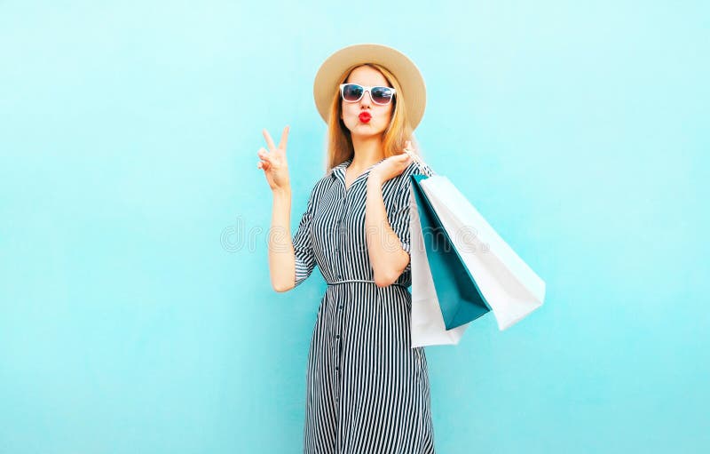 Adatti a ritratto la donna graziosa con i sacchetti della spesa in vestito a strisce immagini stock libere da diritti Adatti a ritratto la donna graziosa con i sacchetti della spesa in vestito a strisce immagini stock libere da diritti