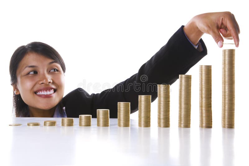 A young Asian businesswoman adding one coins to the highest stack in the most right row. Twelve stack of coins represent twelve months in a year. A young Asian businesswoman adding one coins to the highest stack in the most right row. Twelve stack of coins represent twelve months in a year.