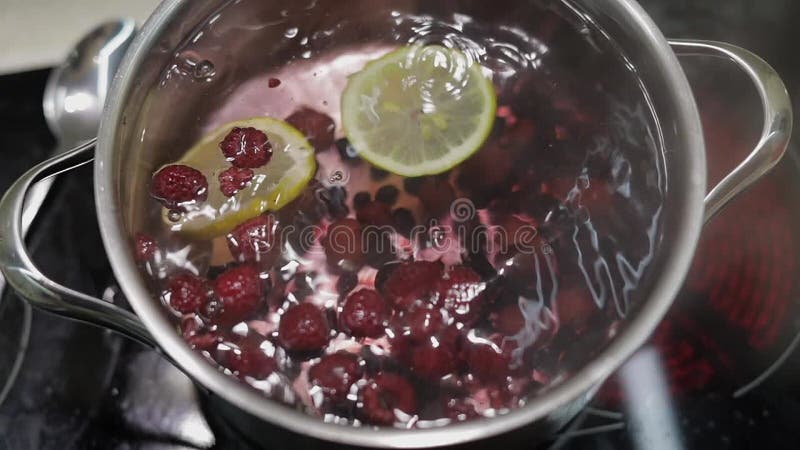 Add slice of lemon in pan with water and berries. Red, black currant, raspberry