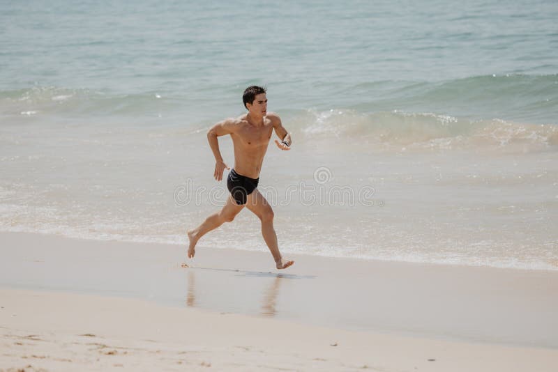 Addestramento corrente del corridore dell'uomo di forma fisica della spiaggia cardio Atleta maschio di stile di vita sano che fa immagine stock Addestramento corrente del corridore dell'uomo di forma fisica della spiaggia cardio Atleta maschio di stile di vita sano che fa immagine stock