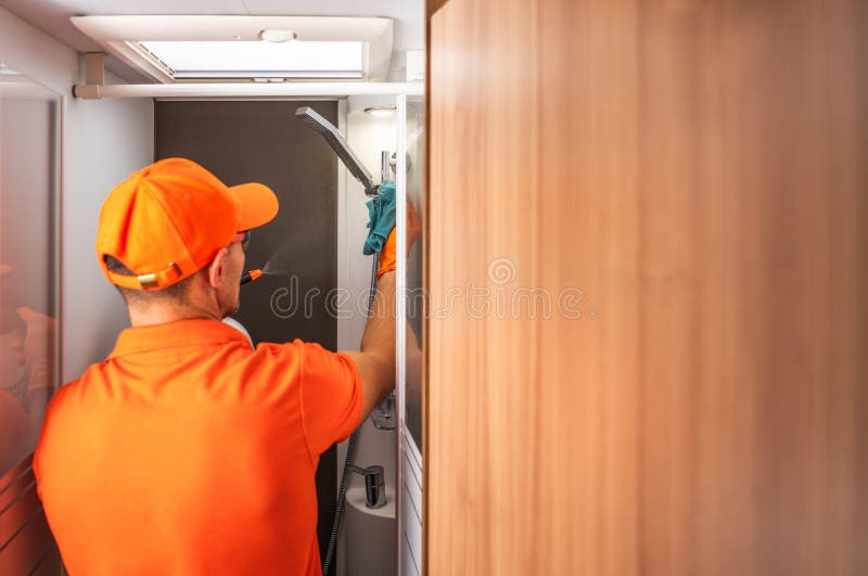 Addetto alla manutenzione pulitura di locali per il trasporto di camper in un locale pubblico durante il giorno fotografia stock libera da diritti