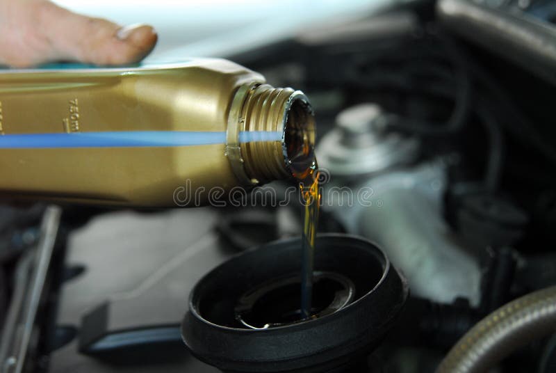 Man's hand holding a bowl of motor oil and poured into the engine. Man's hand holding a bowl of motor oil and poured into the engine