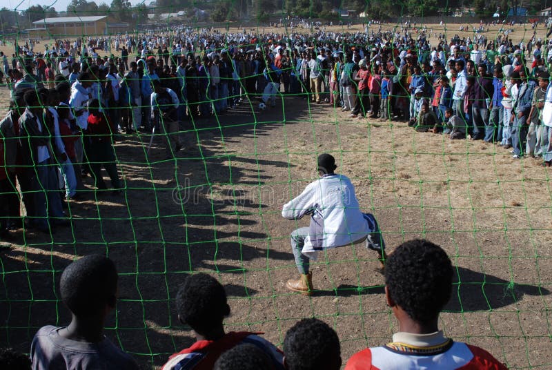 Addis Ababa, Ethiopia: Crowd following a penalty kick betting game. Taking advantage of the gathering to celebrate Epiphany Timkat all sorts of street entertainment is organized at Janmeda Horseracing grounds. Addis Ababa, Ethiopia: Crowd following a penalty kick betting game. Taking advantage of the gathering to celebrate Epiphany Timkat all sorts of street entertainment is organized at Janmeda Horseracing grounds