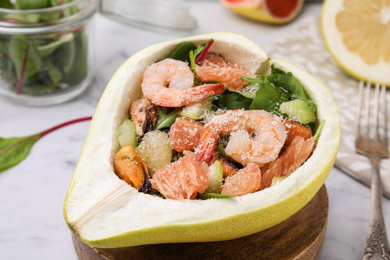 Adekvat pomelosallad med räkor i hälften av frukt på bordsduken royaltyfria bilder