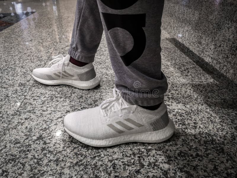 ADIDAS ULTRA BOOST, White and gray shoes on a black ceramic ground royalty free stock photography ADIDAS ULTRA BOOST, White and gray shoes on a black ceramic ground royalty free stock photography