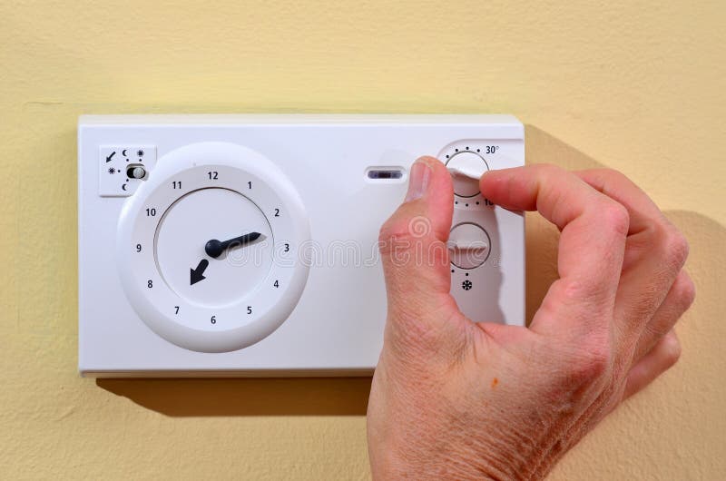 Adjusting thermostat to save on heating stock images