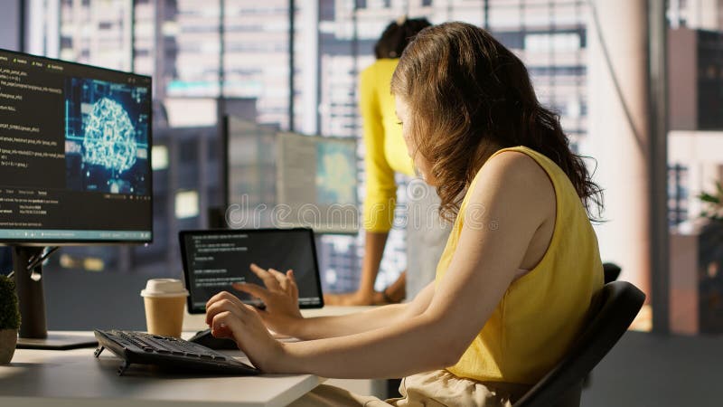 Admin tests on computer and tablet to optimize artificial intelligence tech stock image