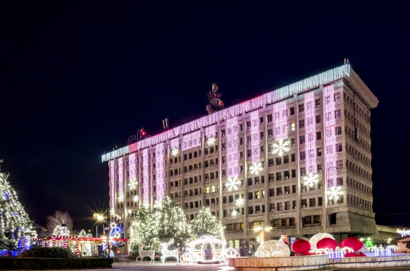 Amministrativa di Palazzo di Ploiesti , in Romania, dove si trova il municipio , decorato con luci colorate nello spirito delle vacanze invernali , babbo Natale in slitta con i cervi , pini e lampadine , nella piazza principale , colpo di notte.