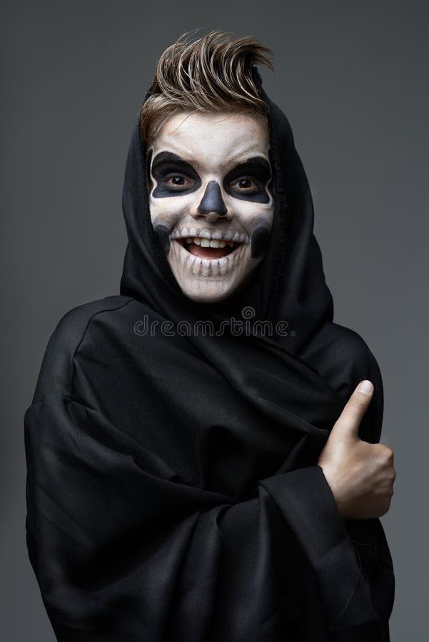 Ado avec le crâne de maquillage montrant des pouces photographie stock libre de droits Ado avec le crâne de maquillage montrant des pouces photographie stock libre de droits