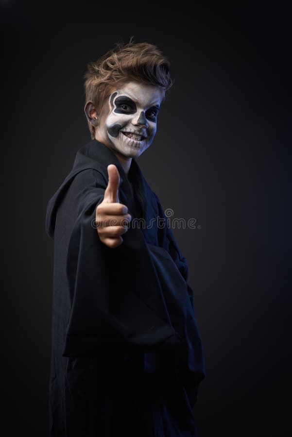 Ado avec le crâne de maquillage montrant des pouces images stock Ado avec le crâne de maquillage montrant des pouces images stock