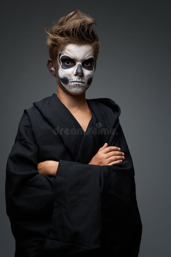 Ado avec le maquillage du crâne dans le cap noir images libres de droits Ado avec le maquillage du crâne dans le cap noir images libres de droits