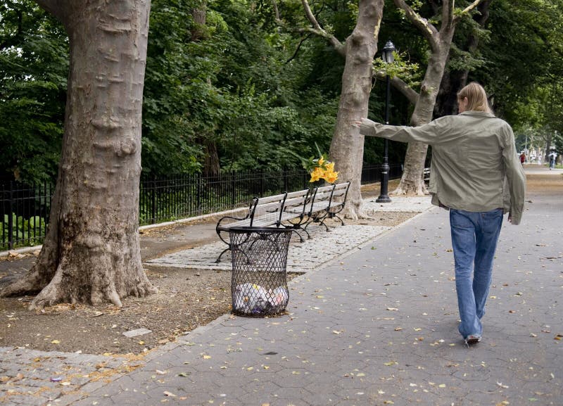 Adolescent boy throwing flowers into tash can.1