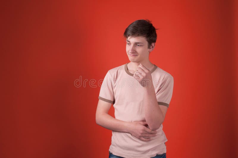 Adolescent de renversement dans la position beige de T-shirt avec la main sur la taille et regarder loin image stock Adolescent de renversement dans la position beige de T-shirt avec la main sur la taille et regarder loin image stock