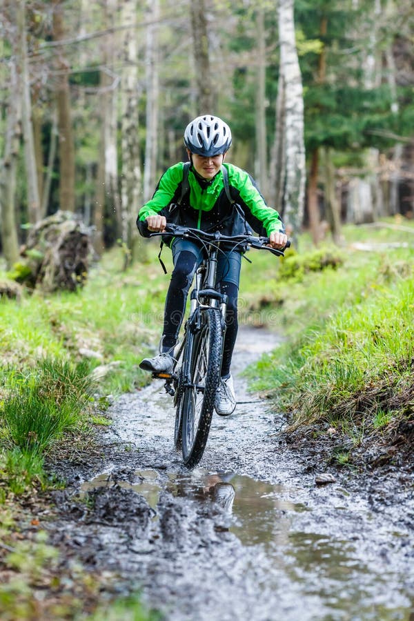 Adolescent faisant du vélo sur des traînées de forêt images stock Adolescent faisant du vélo sur des traînées de forêt images stock