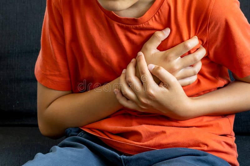 Adolescent garçon caucasien tenant sa poitrine souffrant de douleur coeur skip beat. photo libre de droits