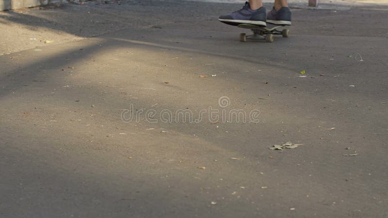 Adolescent masculin apprenant à garder l'équilibre, planche à roulettes de monte, activités en plein air banque de vidéos