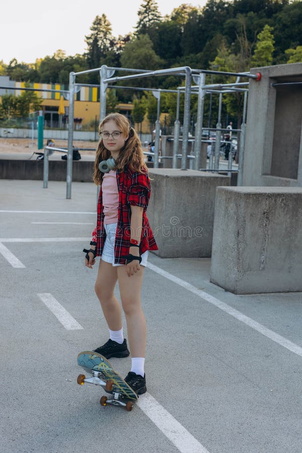 Adolescent patineuse avec un skateboard est assis et se repose dans le parc des patineurs photo libre de droits