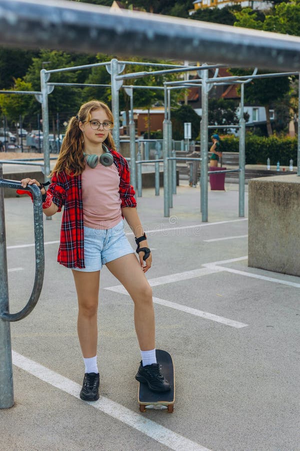 Adolescent patineuse avec un skateboard est assis et se repose dans le parc des patineurs images libres de droits