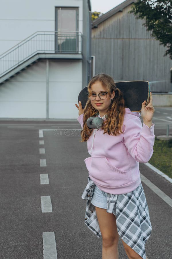 Adolescent patineuse avec un skateboard est assis et se repose dans le parc des patineurs image libre de droits