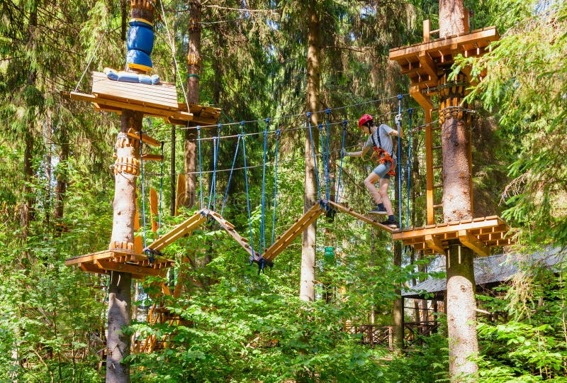 Adolescent pe un curs de frânghie într-un parc de aventuri pe treetop trecând cu un obstacol de frânghie royalty free stock photos