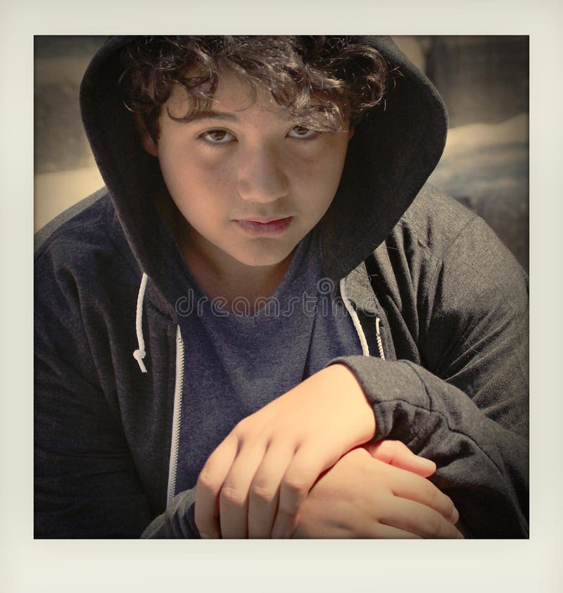 Adolescent préoccupé triste d'école posant la séance extérieure sur la rue vous regardant - fermez-vous du visage avec des couleu photographie stock Adolescent préoccupé triste d'école posant la séance extérieure sur la rue vous regardant - fermez-vous du visage avec des couleu photographie stock