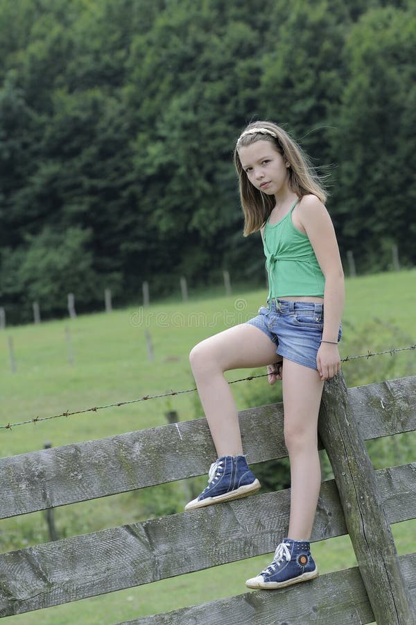 Adolescent standing on fence
