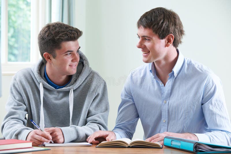 Adolescent étudiant avec le tuteur à la maison image stock