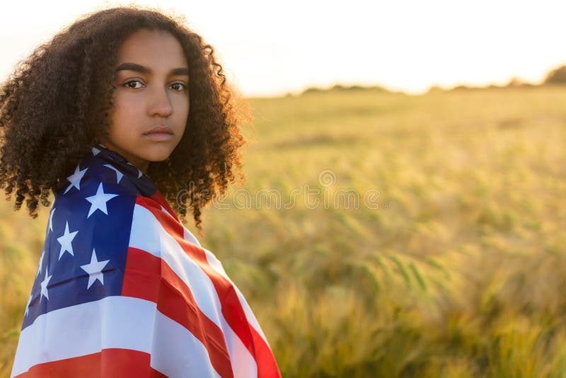 Adolescente afroamericano de la muchacha de la raza mixta triste con el campo de la bandera de los E.E.U.U. imagen de archivo libre de regalías Adolescente afroamericano de la muchacha de la raza mixta triste con el campo de la bandera de los E.E.U.U. imagen de archivo libre de regalías