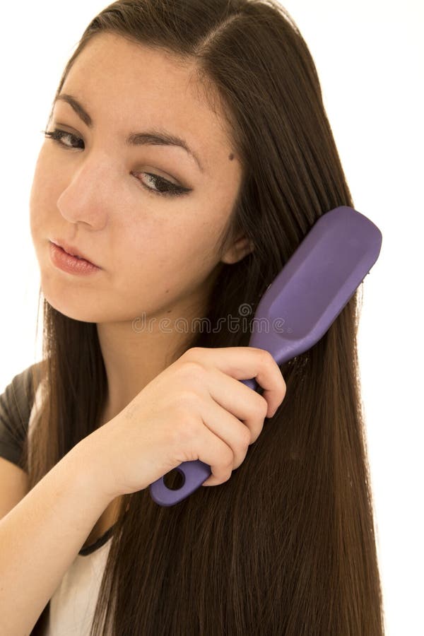 Asian American teen brushing her dark hair. Asian American teen brushing her dark hair